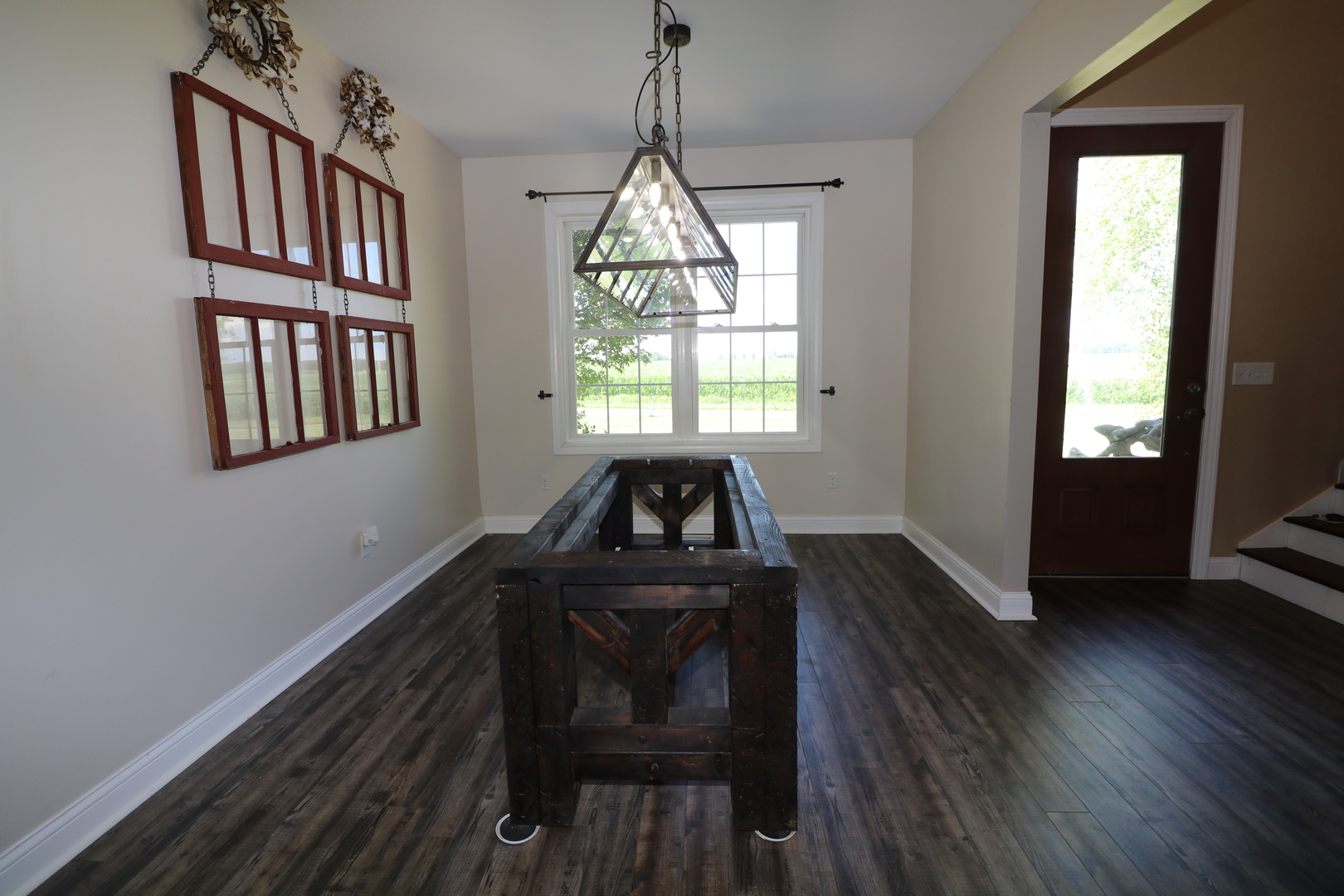 9358 Little Galilee Road Clinton, IL 61727 - Photo 4 of 40 a dining room with wooden floor a chandelier a wooden table and chairs