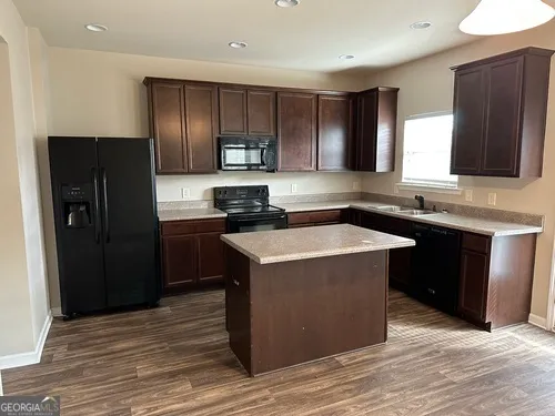 a kitchen with a refrigerator sink and cabinets