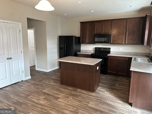 a kitchen with granite countertop a stove top oven and cabinets