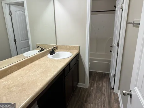 a bathroom with a granite countertop sink and a mirror