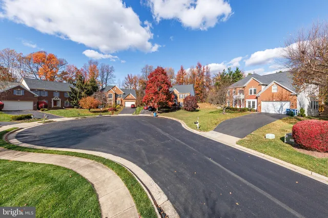 a view of yellow house with a yard and large trees