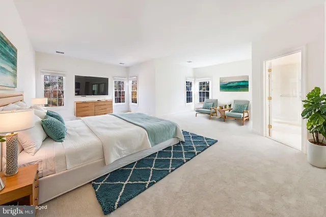 a bedroom with a large bed and a flat tv screen