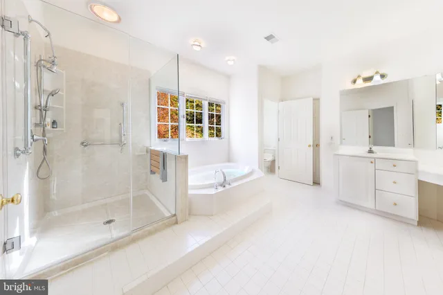 a spacious bathroom with a shower sink and mirror
