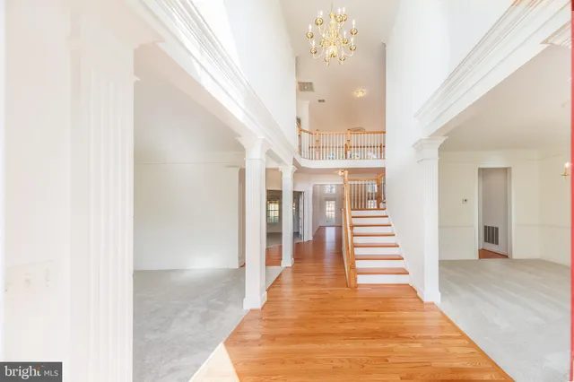 a view of a hallway with wooden floor and staircase
