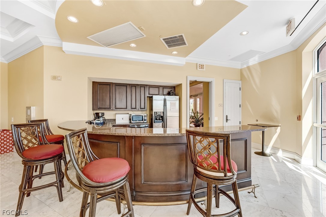 2743 First Street, Unit 2102 Fort Myers, FL 33916 - Photo 38 of 42 a room with stainless steel appliances kitchen island granite countertop furniture and a kitchen view