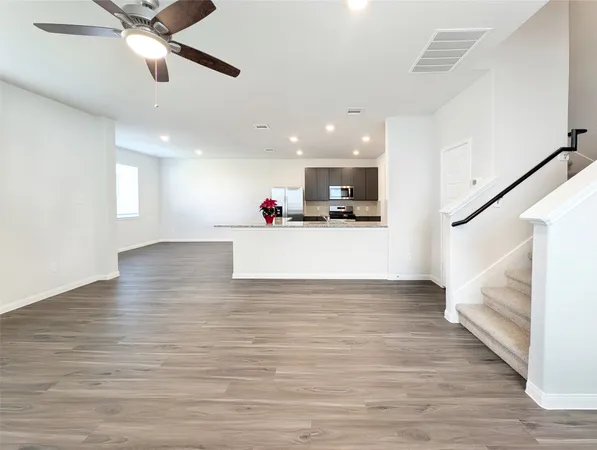 a view of a kitchen with a sink and dishwasher with wooden floor