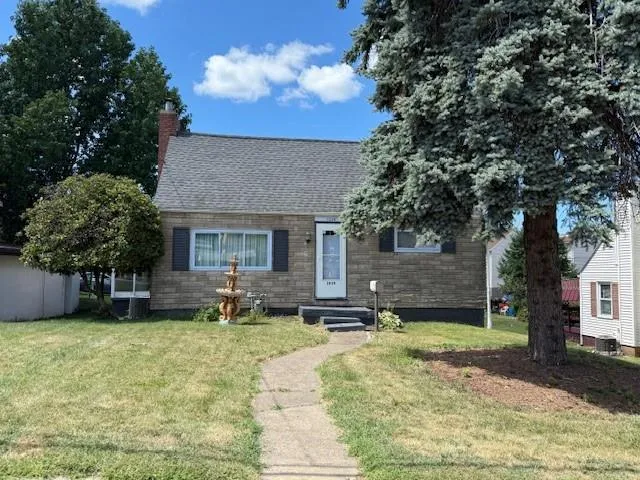 a view of a house with a yard and sitting area