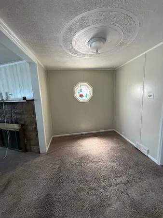 a view of empty room with kitchen