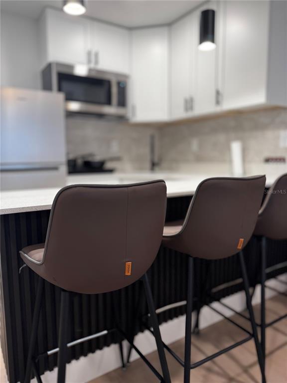 43420 Highway 27, Unit 414 Davenport, FL 33837 - Photo 19 of 41 a kitchen with a table chairs and a microwave