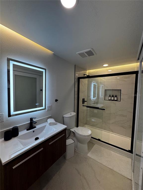 43420 Highway 27, Unit 414 Davenport, FL 33837 - Photo 20 of 41 a bathroom with a toilet sink double vanity shower and mirror