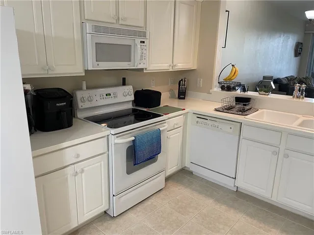 a room with cabinets and white appliances