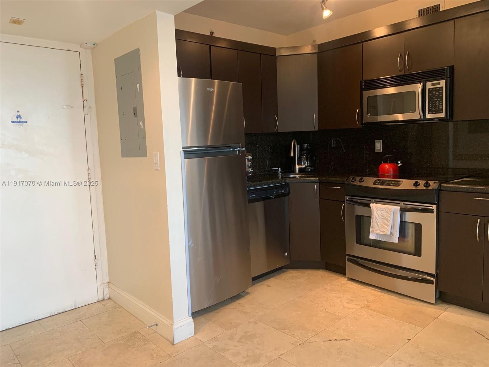 100 Lincoln Road, Unit 1122 Miami Beach, FL 33139 - Photo 13 of 29 a kitchen with a refrigerator and a stove top oven