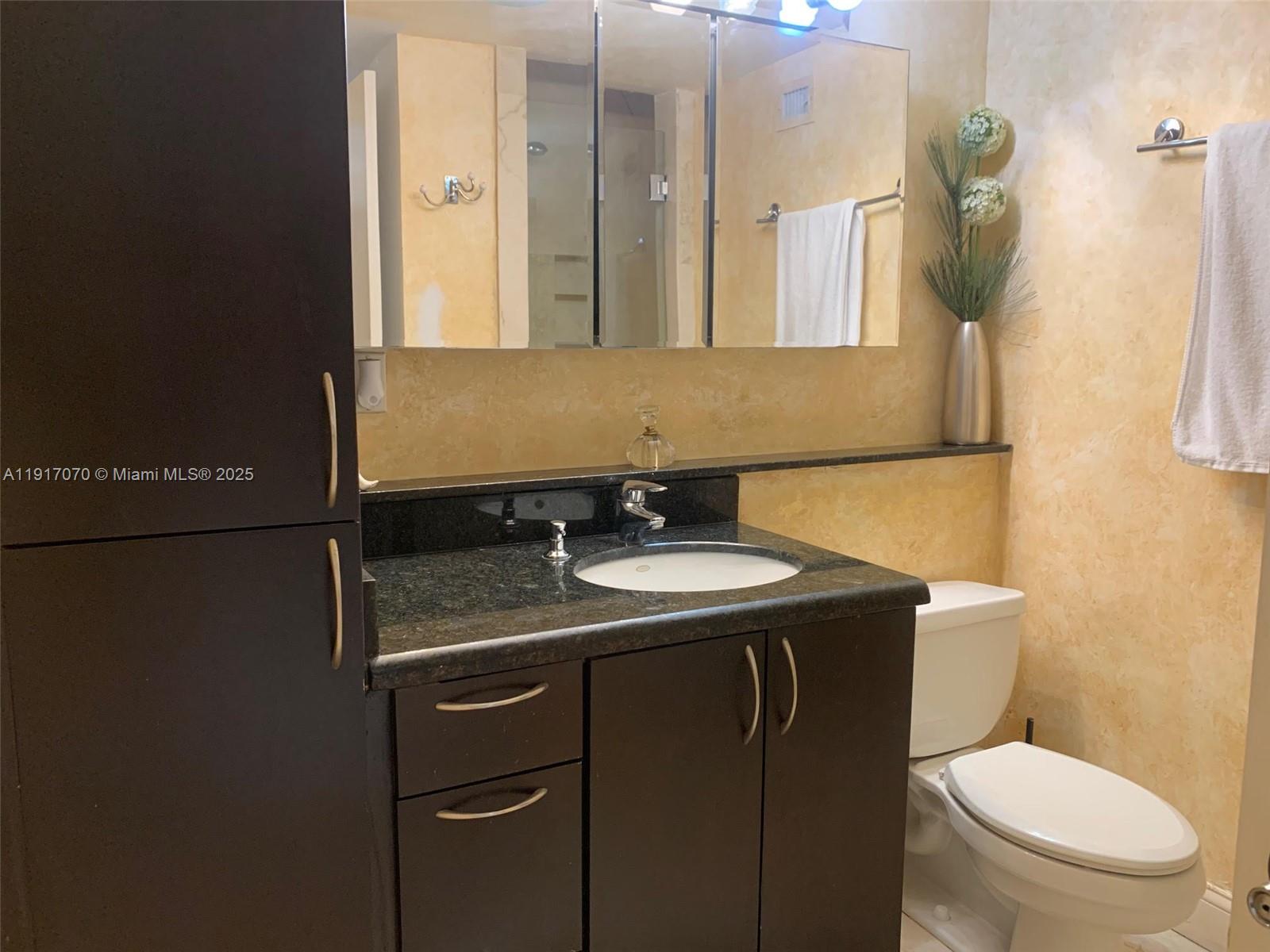 100 Lincoln Road, Unit 1122 Miami Beach, FL 33139 - Photo 16 of 29 a bathroom with a granite countertop toilet sink and mirror
