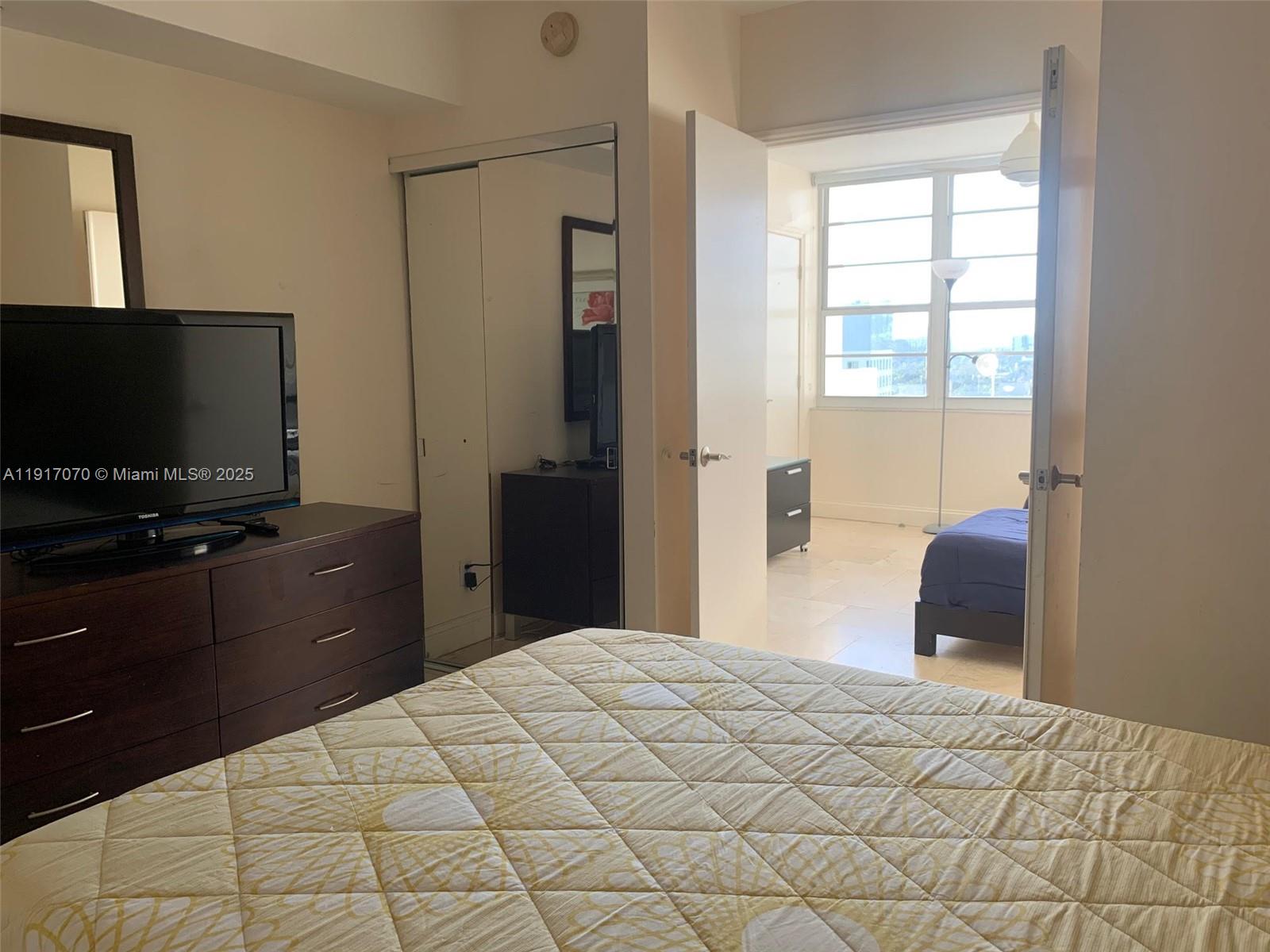 100 Lincoln Road, Unit 1122 Miami Beach, FL 33139 - Photo 19 of 29 a bedroom with a bed and a flat screen tv