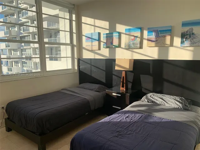 a bedroom with two beds and a window