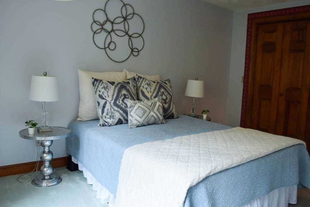 111 Bear Hill Road North Andover, MA 01845 - Photo 32 of 41 a bedroom with a bed and a chandelier