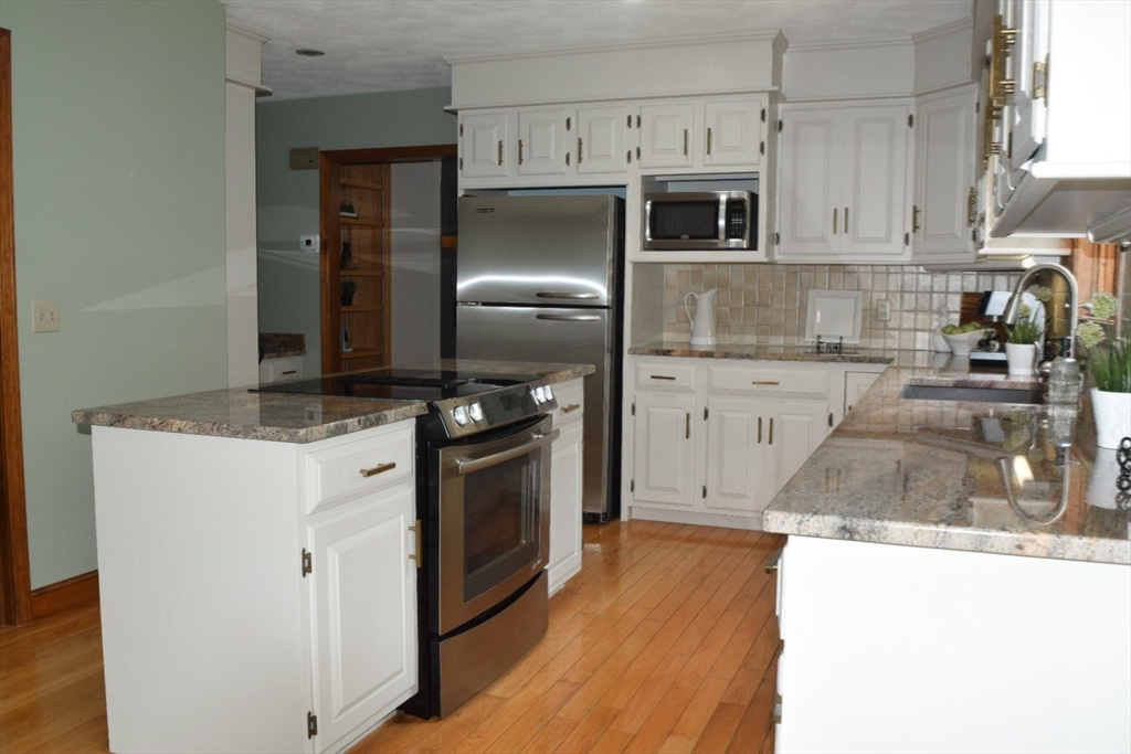 111 Bear Hill Road North Andover, MA 01845 - Photo 8 of 41 a kitchen with granite countertop a stove and a refrigerator