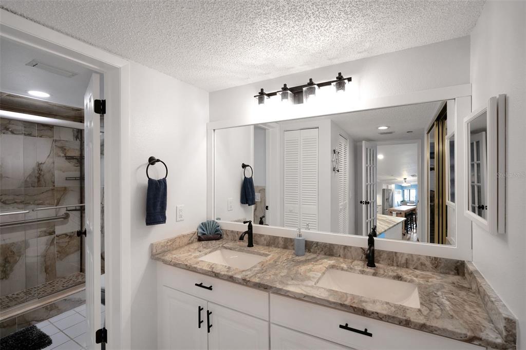 6035 Sea Ranch Drive, Unit 215 Hudson, FL 34667 - Photo 18 of 76 a bathroom with a granite countertop sink and a mirror