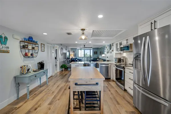 a kitchen with a refrigerator a stove top oven a dining table and chairs