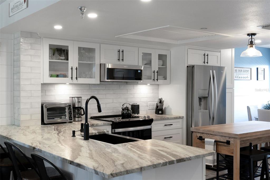 6035 Sea Ranch Drive, Unit 215 Hudson, FL 34667 - Photo 10 of 76 a kitchen with refrigerator and cabinets