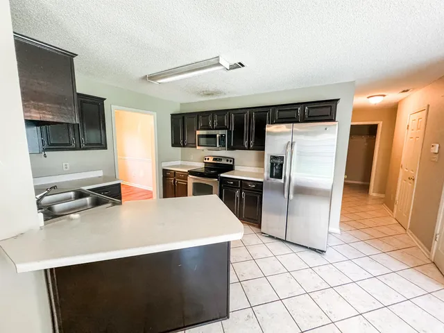 a kitchen with stainless steel appliances a refrigerator stove microwave and sink