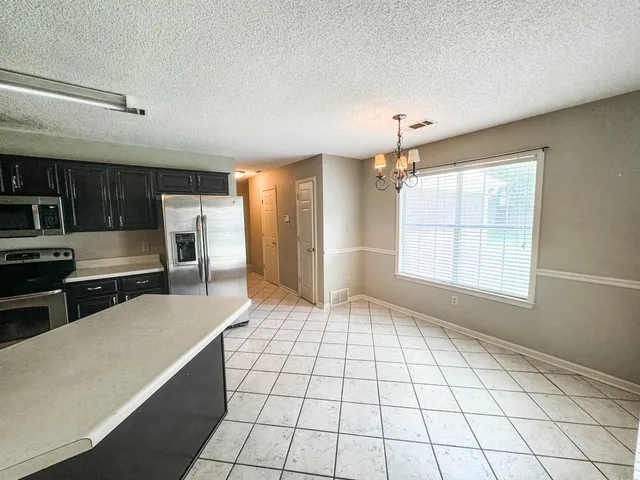a kitchen with stainless steel appliances a refrigerator sink and cabinets