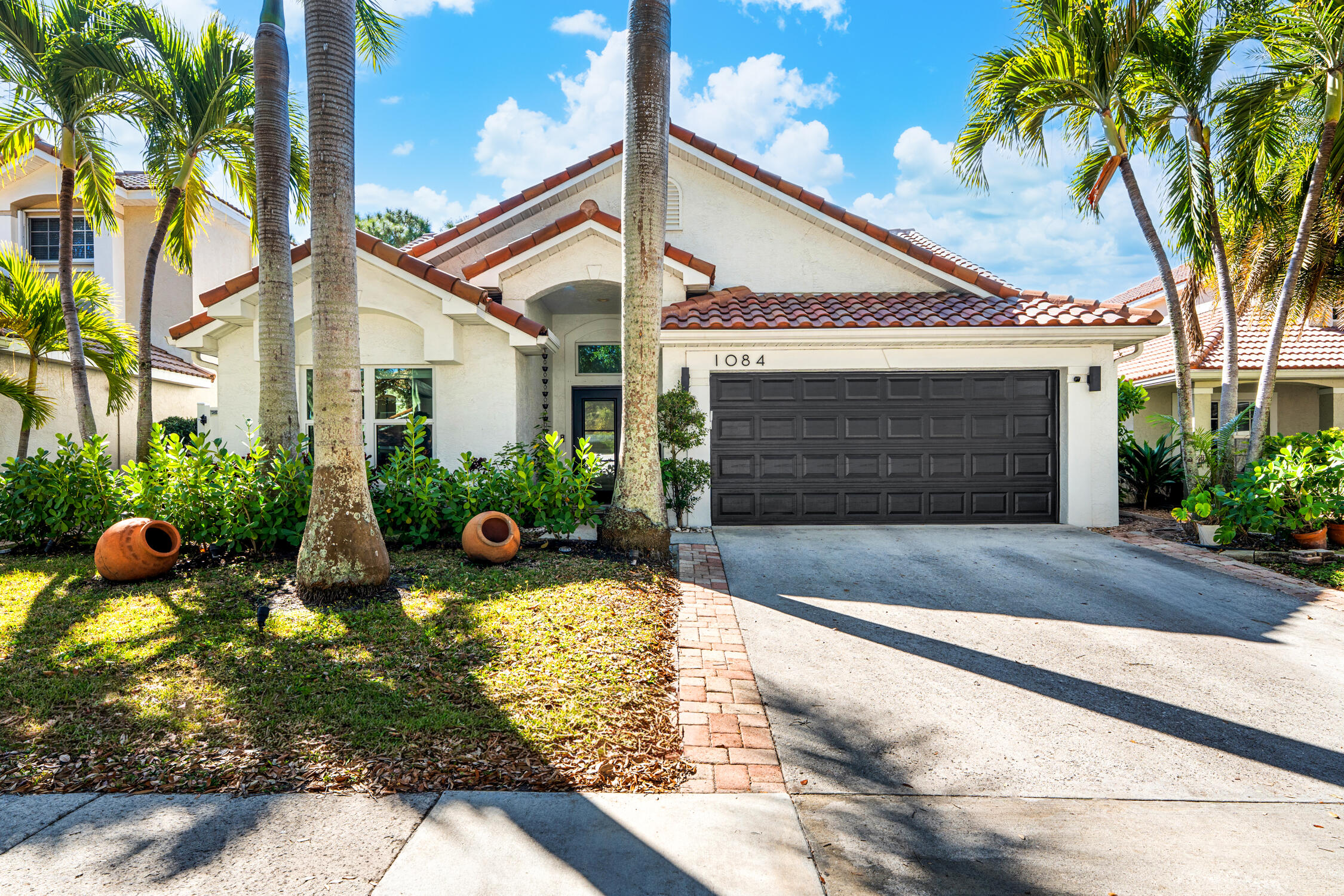 1084 Anchor Point Delray Beach, FL 33444 - Photo 1 of 25 a front view of a house with garden and plants