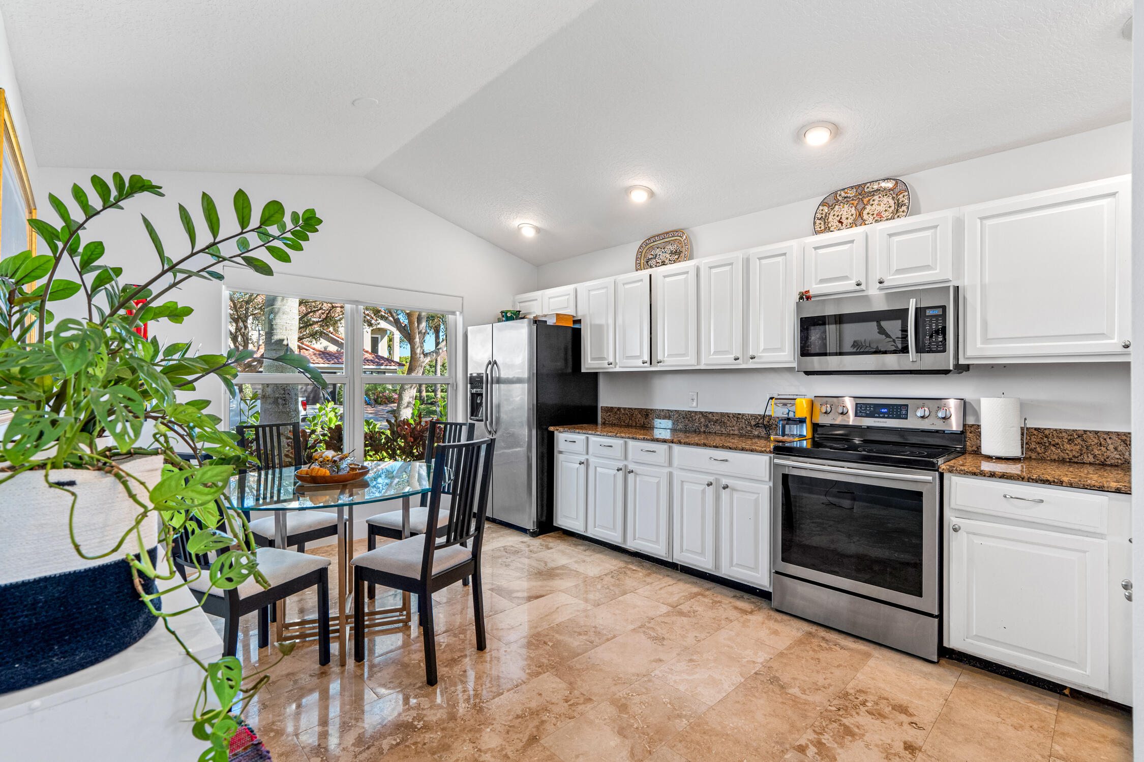 1084 Anchor Point Delray Beach, FL 33444 - Photo 3 of 25 a kitchen with stainless steel appliances a stove a sink cabinets and a dining table
