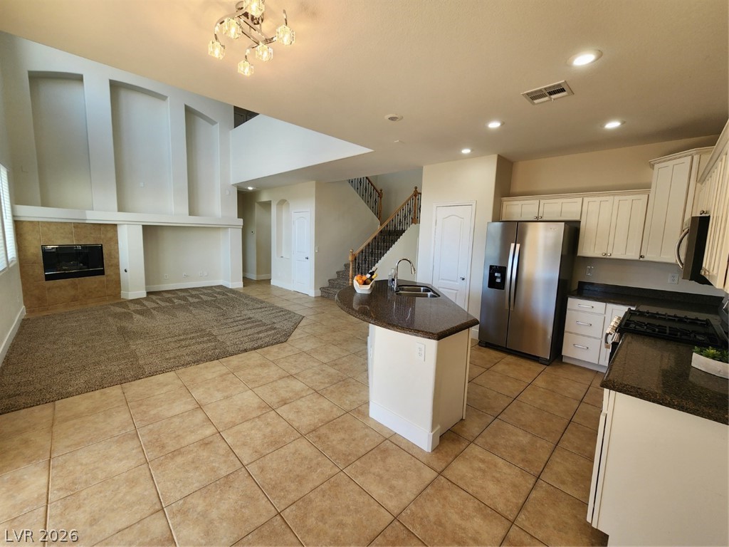 716 Sharon Hills Street Henderson, NV 89052 - Photo 65 of 66 Kitchen with dark stone counters, refrigerator, open floor plan, an island with sink, and stove