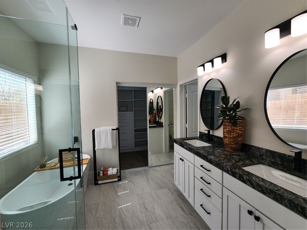716 Sharon Hills Street Henderson, NV 89052 - Photo 17 of 66 Full bathroom with plenty of natural light, double vanity, a freestanding tub, and a walk in closet