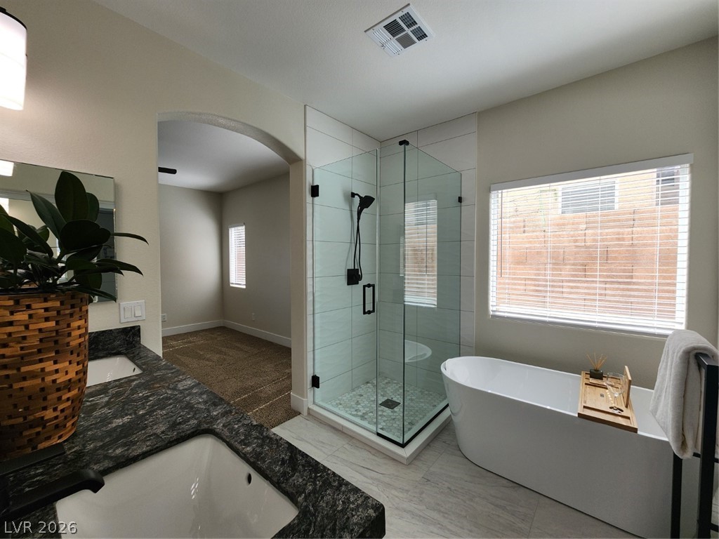 716 Sharon Hills Street Henderson, NV 89052 - Photo 18 of 66 Full bathroom featuring double vanity, a stall shower, a soaking tub, and light marble finish floors