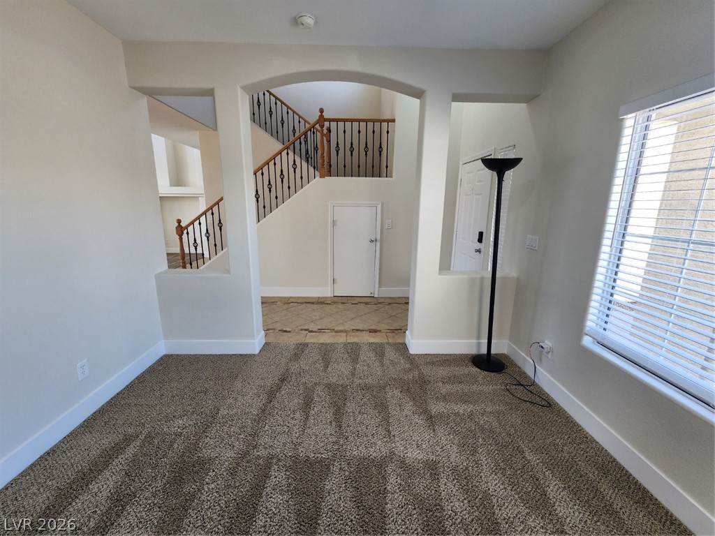 716 Sharon Hills Street Henderson, NV 89052 - Photo 23 of 66 Empty room with dark carpet and arched walkways