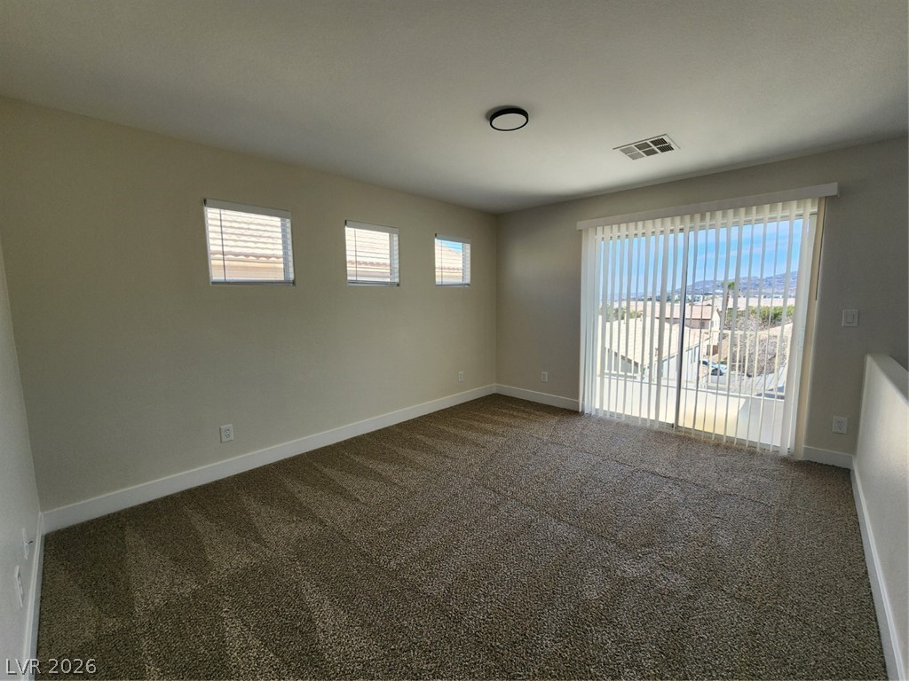 716 Sharon Hills Street Henderson, NV 89052 - Photo 30 of 66 Spare room featuring dark colored carpet and baseboards