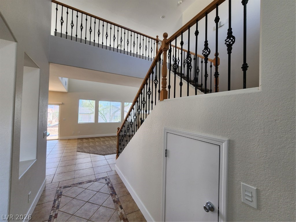 716 Sharon Hills Street Henderson, NV 89052 - Photo 6 of 66 Staircase featuring inlaid floor details, tile patterned floors, and a textured wall