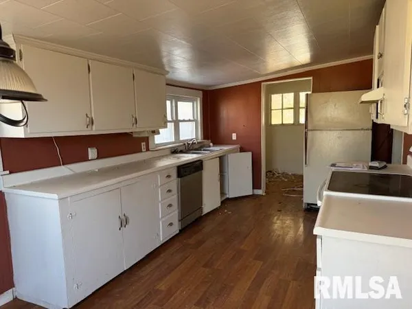 a kitchen with a sink cabinets and wooden floor