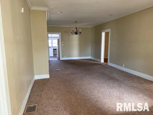 an empty room with windows and cabinet
