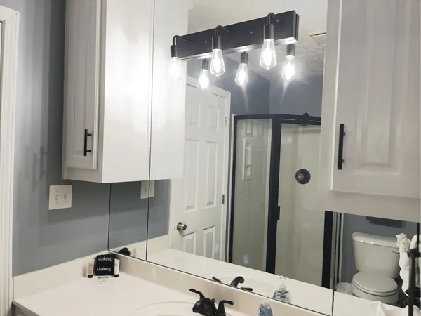 a white toilet sitting next to a bathroom sink and vanity