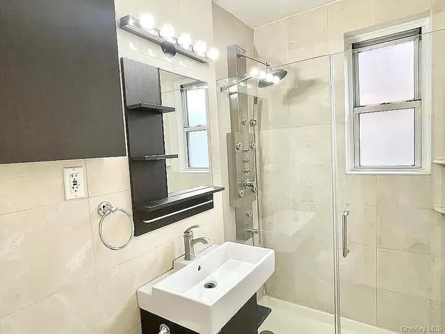 a bathroom with a shower sink and mirror