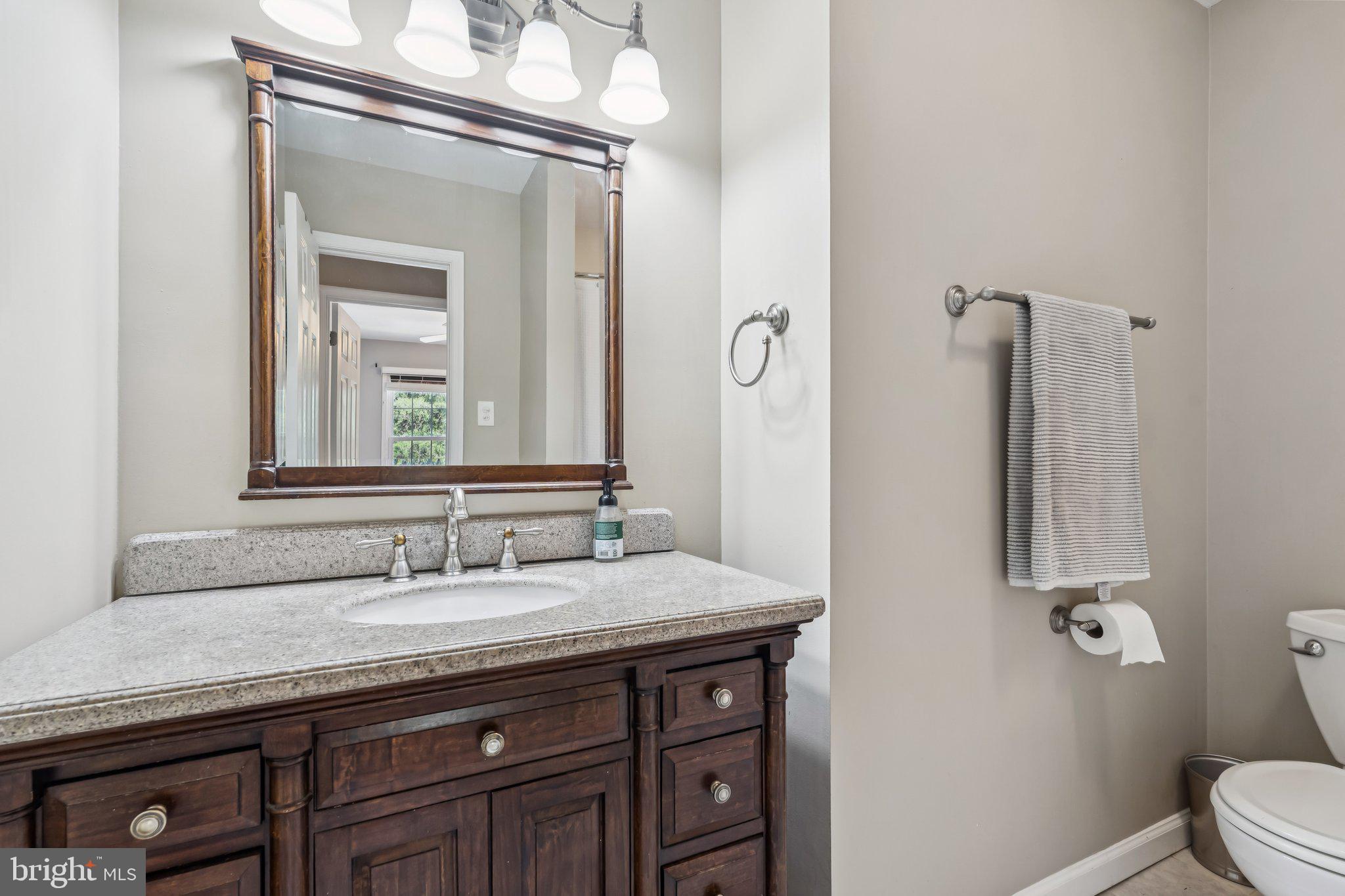 2408 Wanda Way Reston, VA 20191 - Photo 22 of 45 a bathroom with a granite countertop sink a toilet and a mirror