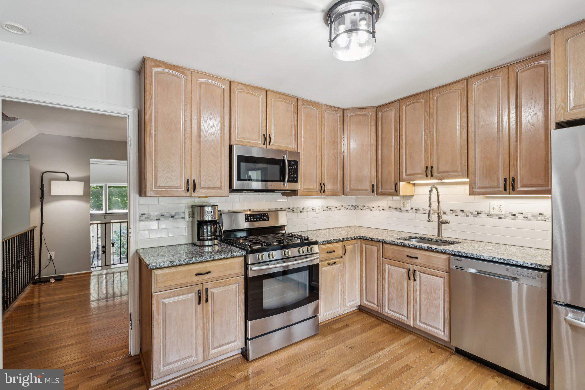2408 Wanda Way Reston, VA 20191 - Photo 3 of 45 a kitchen with granite countertop a sink stainless steel appliances and cabinets