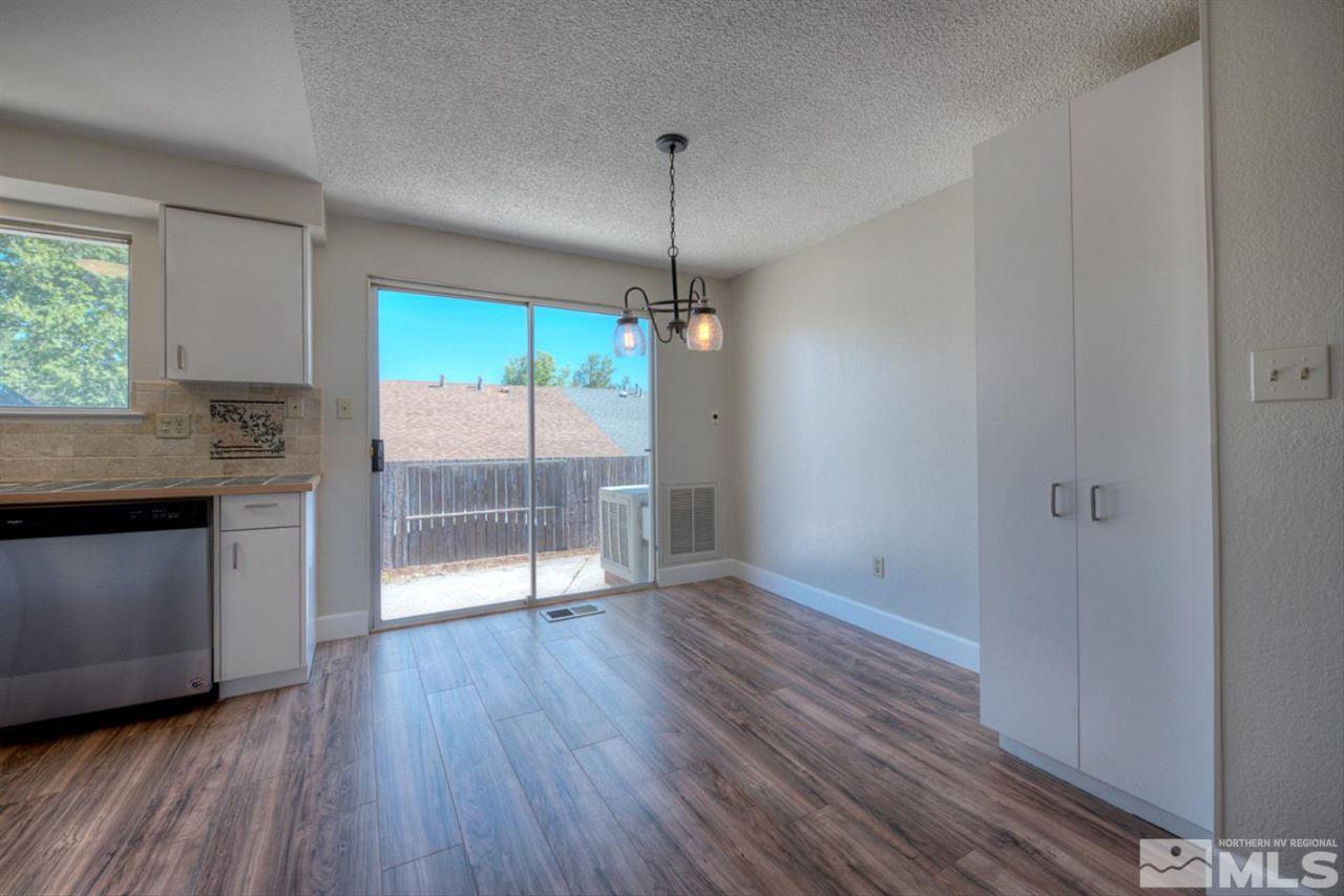 6815 Flower Street Reno, NV 89506 - Photo 11 of 25 a kitchen with granite countertop wooden floors and white walls