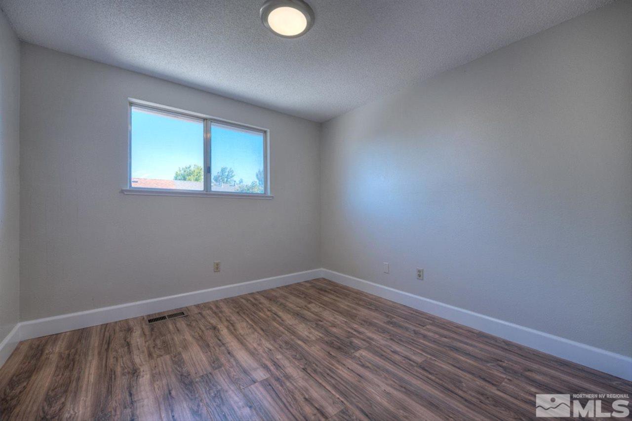 6815 Flower Street Reno, NV 89506 - Photo 14 of 25 a view of an empty room with wooden floor and a window