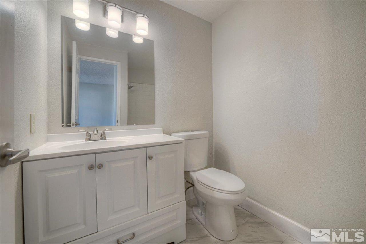 6815 Flower Street Reno, NV 89506 - Photo 9 of 25 a bathroom with a toilet sink and mirror
