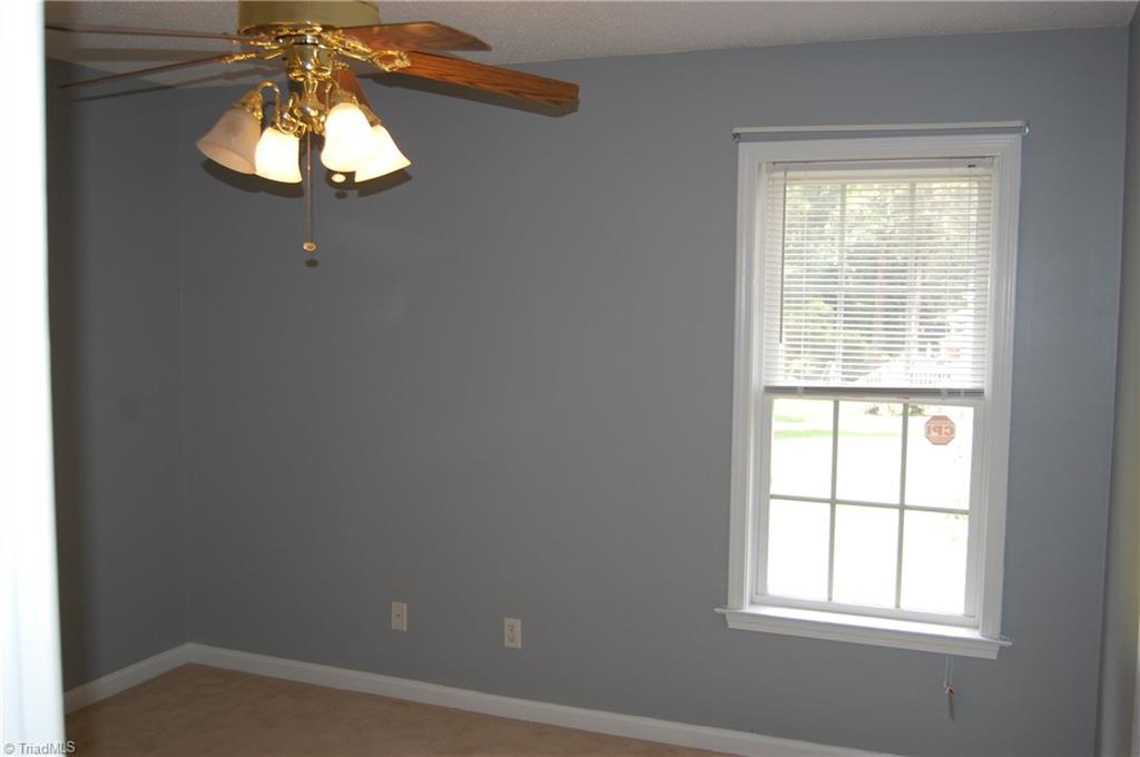 4301 Edgemore Road Greensboro, NC 27455 - Photo 14 of 19 Bedroom #3 with ceiling fan and updated closet shelving