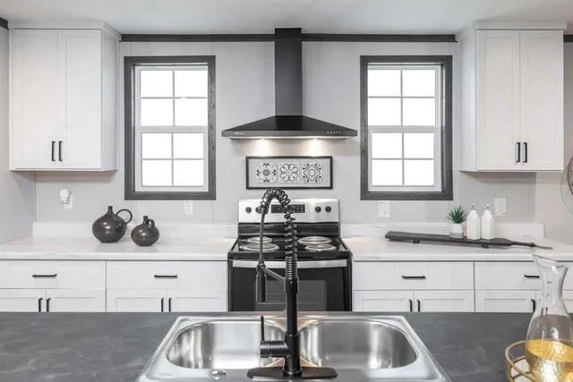 a kitchen with a sink and a stove next to a window