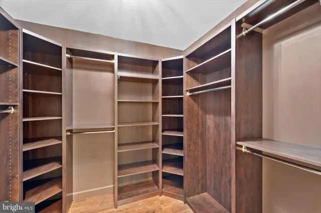 a view of walk in closet with empty racks