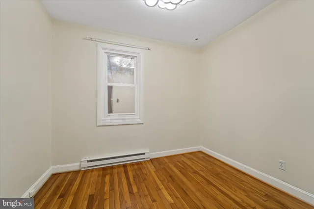 a view of a room with wooden floor and small window
