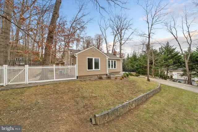 a view of a house with a backyard and wooden fence