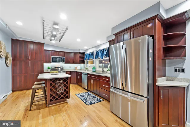 a kitchen with stainless steel appliances granite countertop a refrigerator and a stove top oven