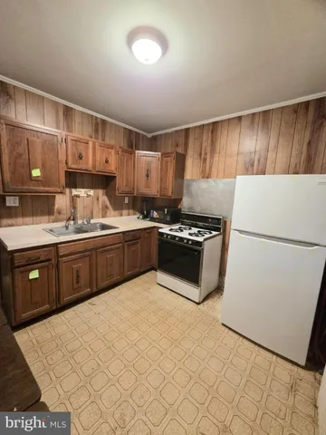 a kitchen with a sink a stove and cabinets